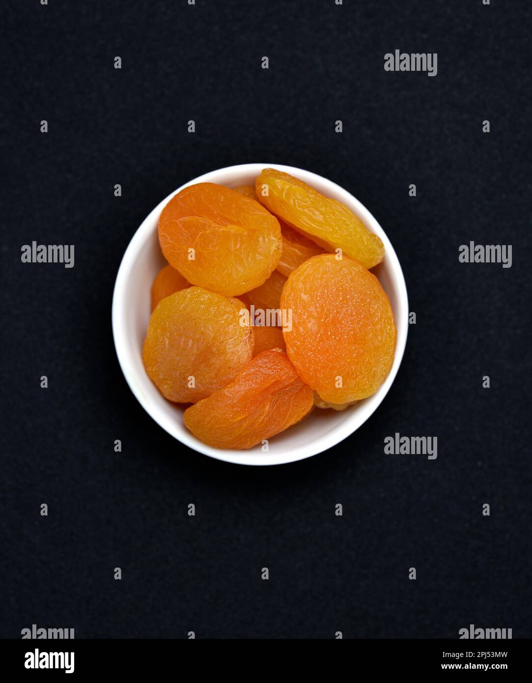 Juicy dried apricots in a white ceramic bowl. Dried apricot fruit