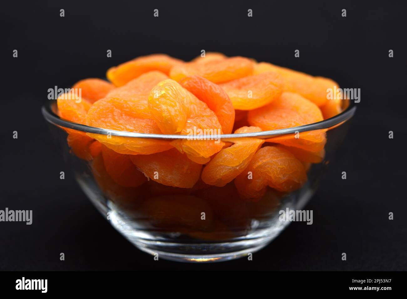Juicy dried apricots in a glass bowl. Dried apricot fruit halves