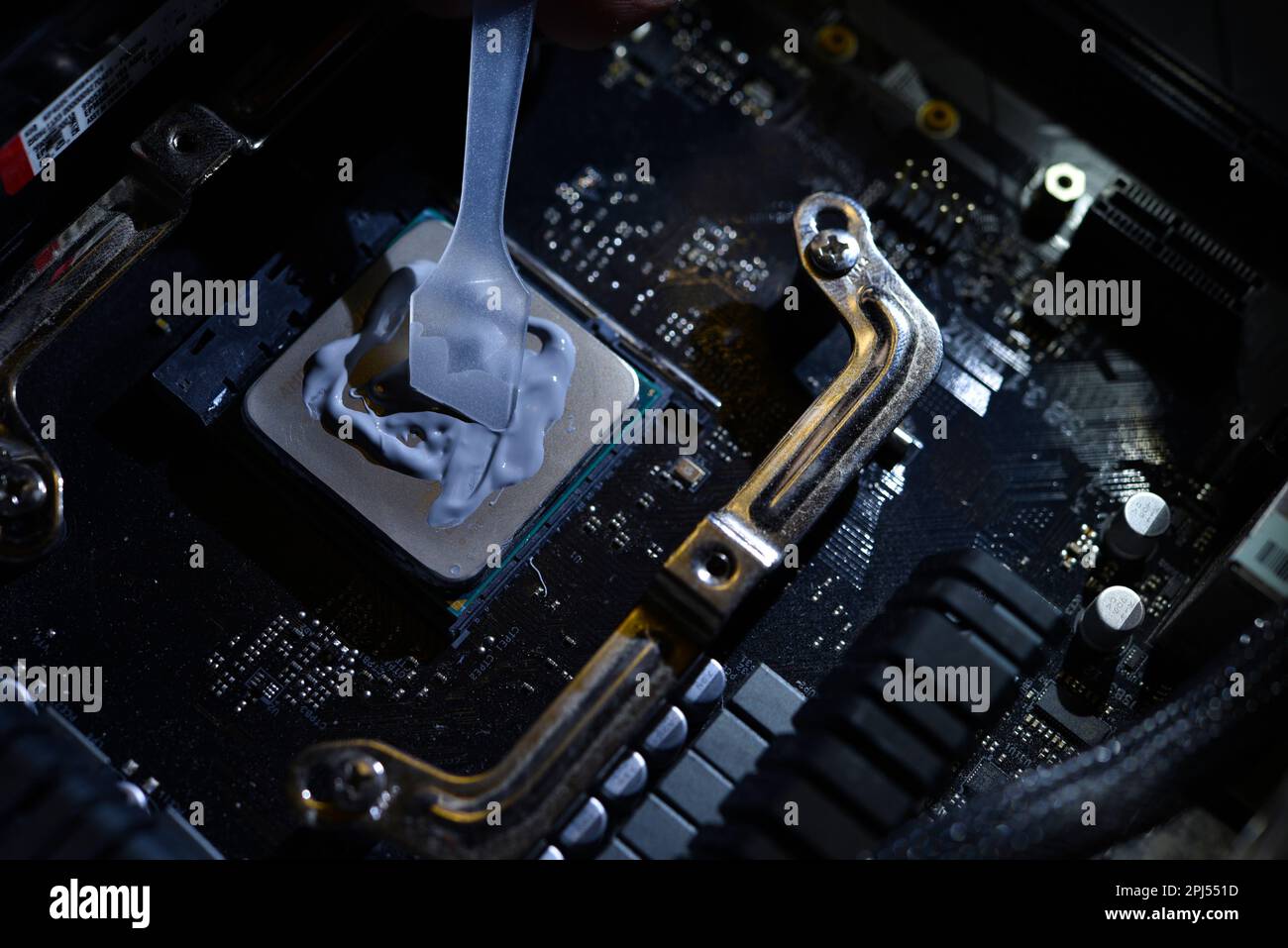 Applying thermal paste to the surface of the computer processor. Thermal interface on the
