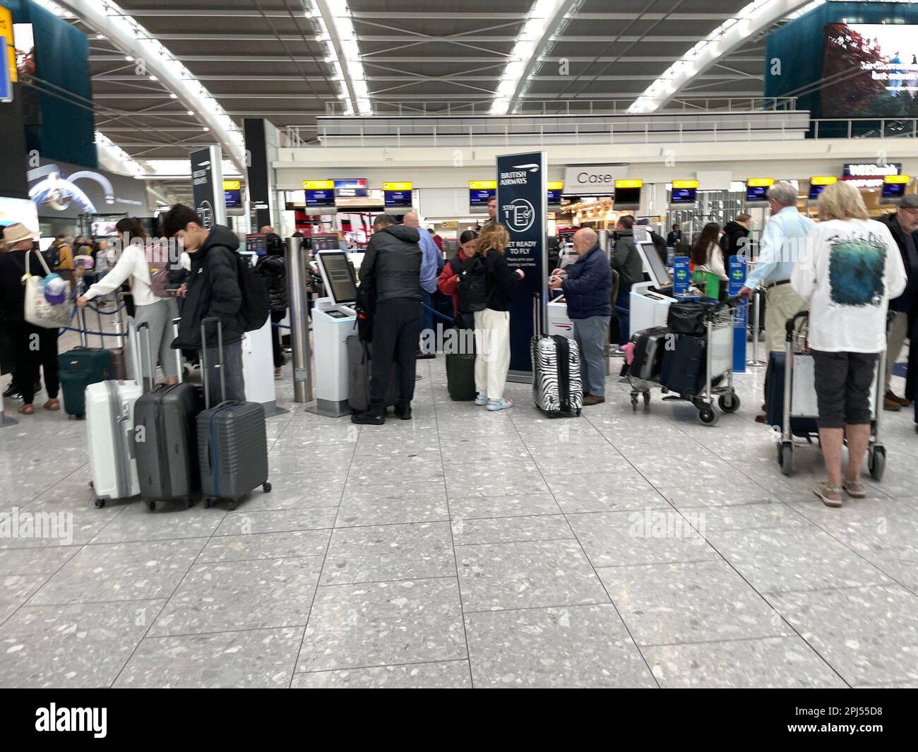 Passengers Wait In Line To Check In At Terminal 5 Of Heathrow Airport