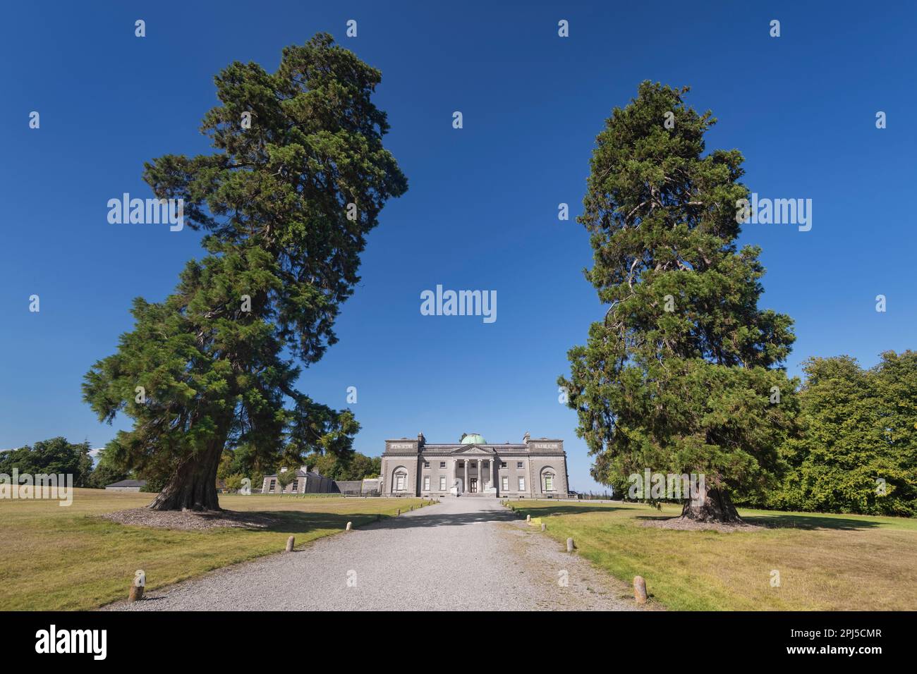 Ireland, County Laois, Emo Court, Facade of the house framed by two tall trees, Emo Court is a