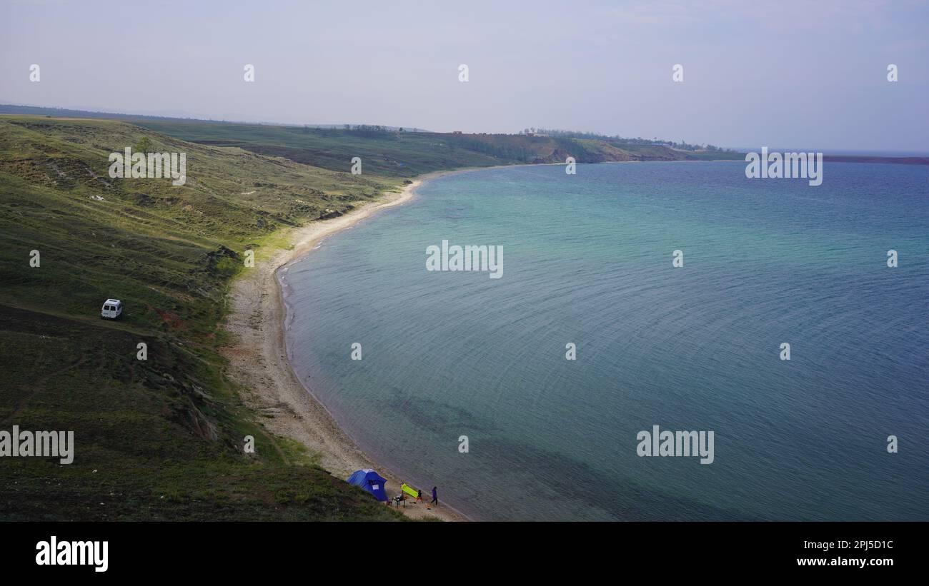A landscape of the sea surrounded by cliffs and greenery in the morning ...