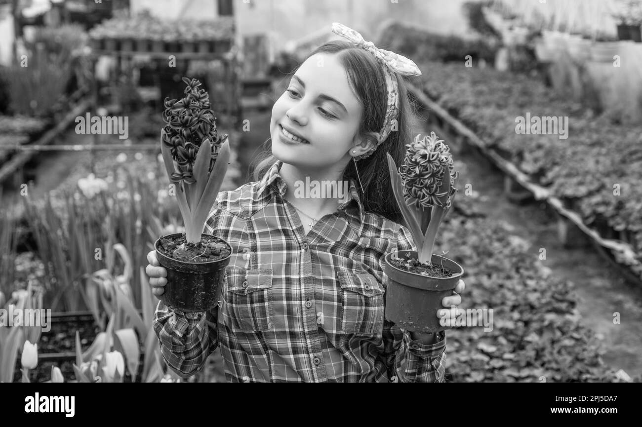 happy teen girl florist care pot plants in greenhouse, summer Stock Photo