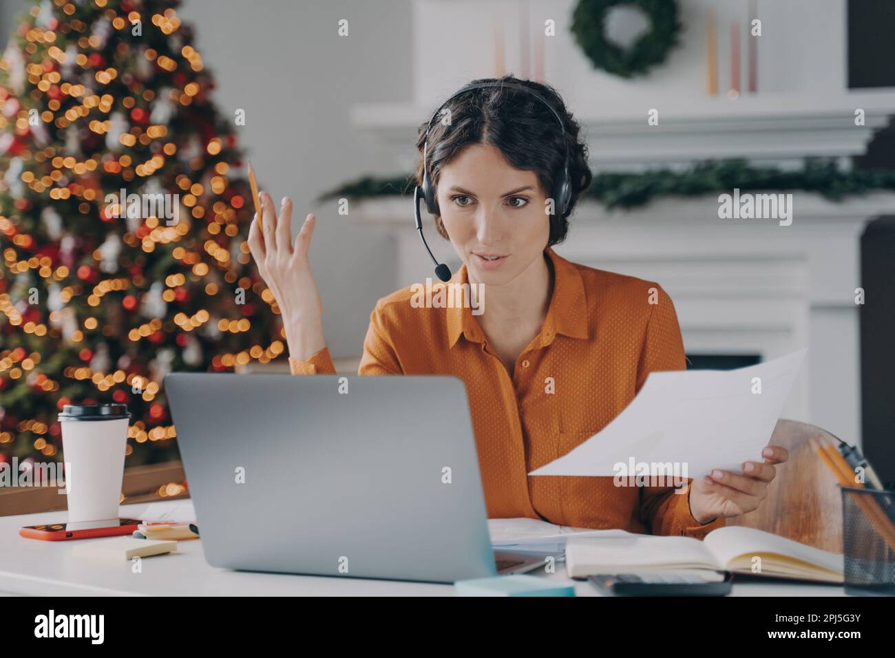 Serious spanish woman teacher in wireless headset with microphone