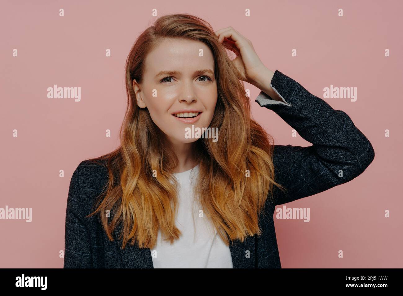 Attractive pensive young woman with wavy ginger hair in formal dark
