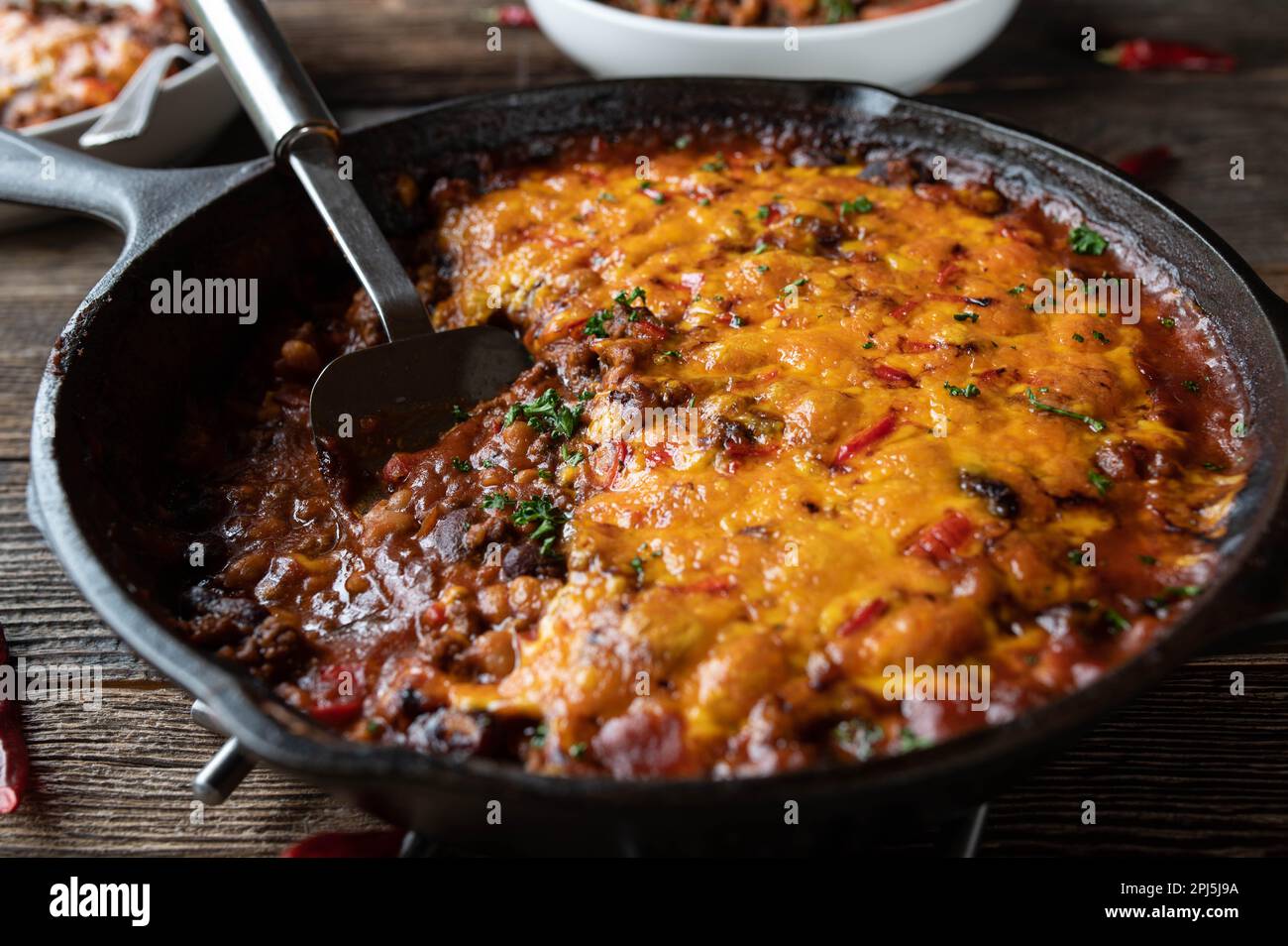 Tex mex stew with beans, ground beef, vegetables and cheddar cheese topping. Stock Photo