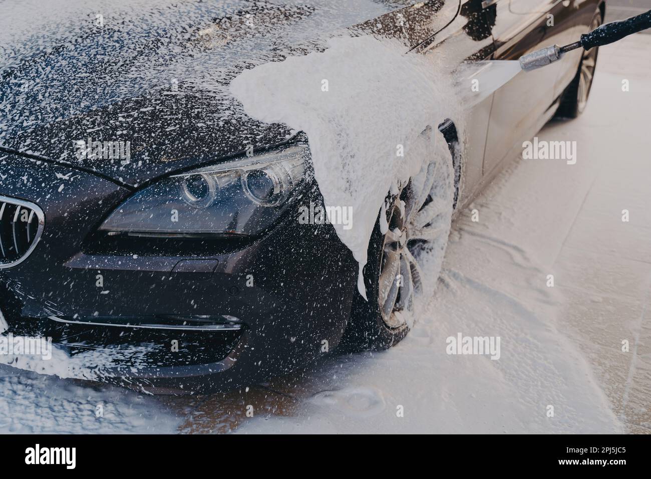 Efficient vehicle cleaning, spraying detergent on vehicle with high