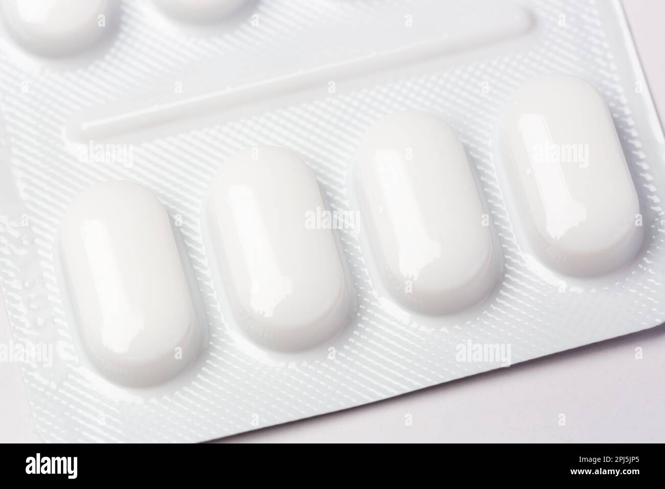 Close up of pills in white plastic blister pack Stock Photo
