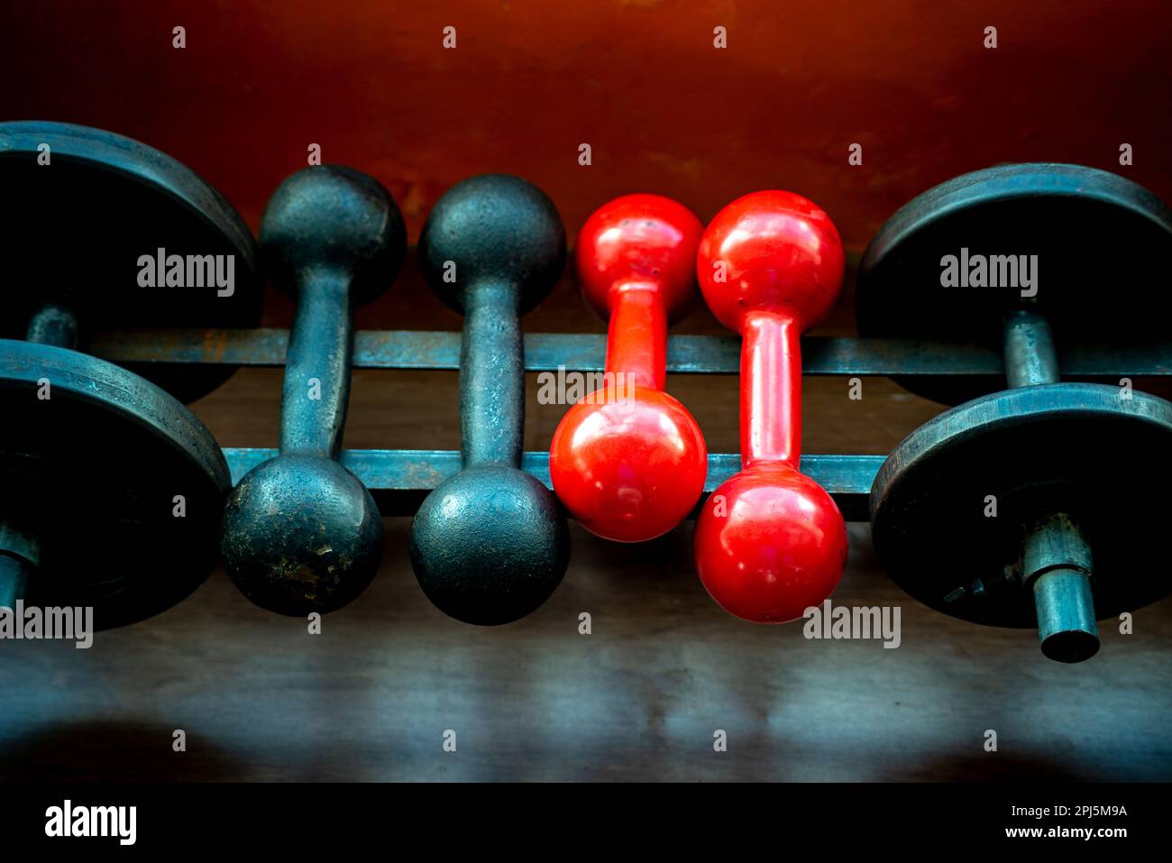 Dumbbell arranged in a row in the gym. Iron material, heavy Stock Photo