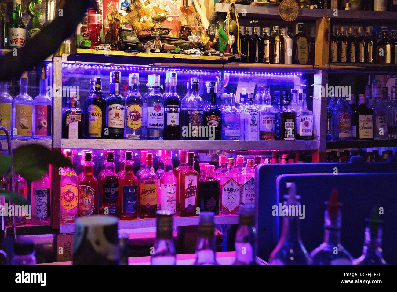 A bar in khaosan road in Bangkok, Thailand with alcohol bottles that are colorfully lit Stock