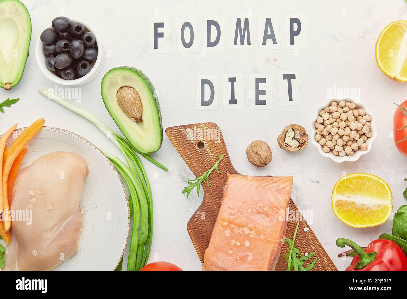 Low fodmap ingredients diet - seafish, vegetables and fruits, nuts, greens, beans. Fodmap diet concept with text in center. Flat lay. Stock Photo