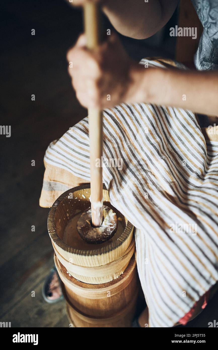 Woman making butter with butter churn. Old traditional method making of
