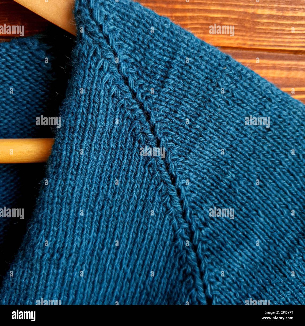 Handmade sweater. Knitted fabric from a green thread on a brown ...