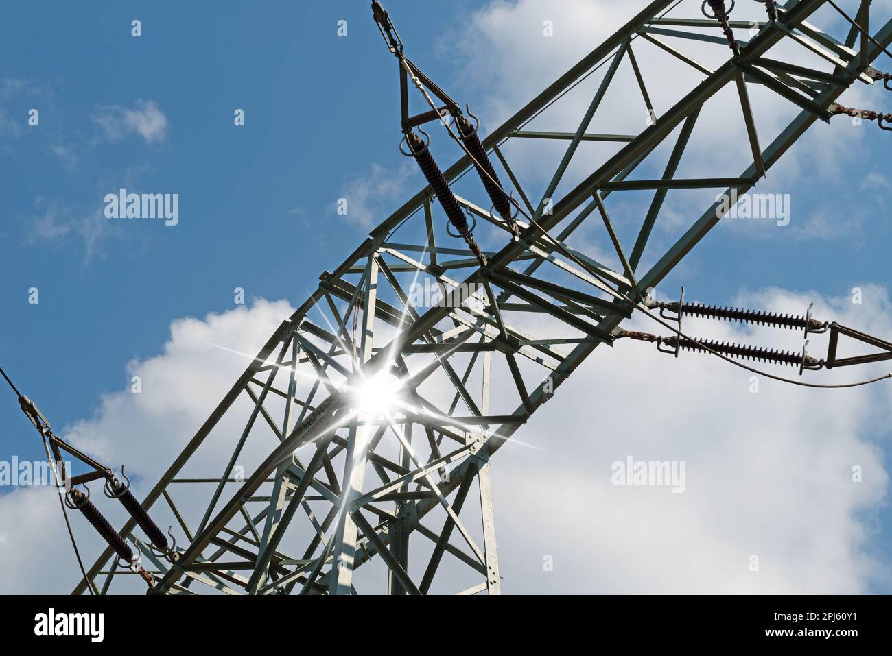 Power line pylon in front of sky with clouds Stock Photo