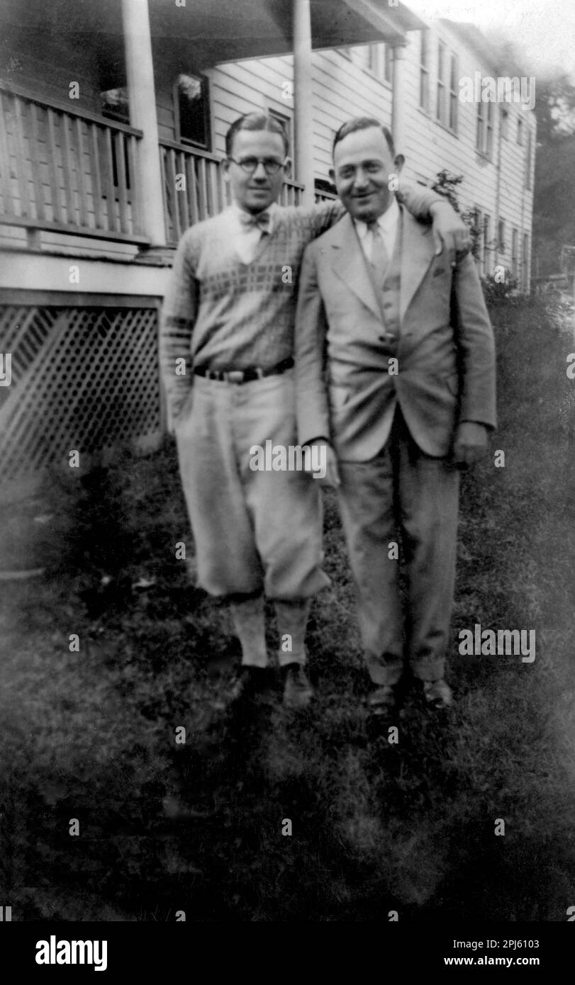 Circa 1930-1940: 2 men standing outdoors; one wearing knickers. Stock Photo