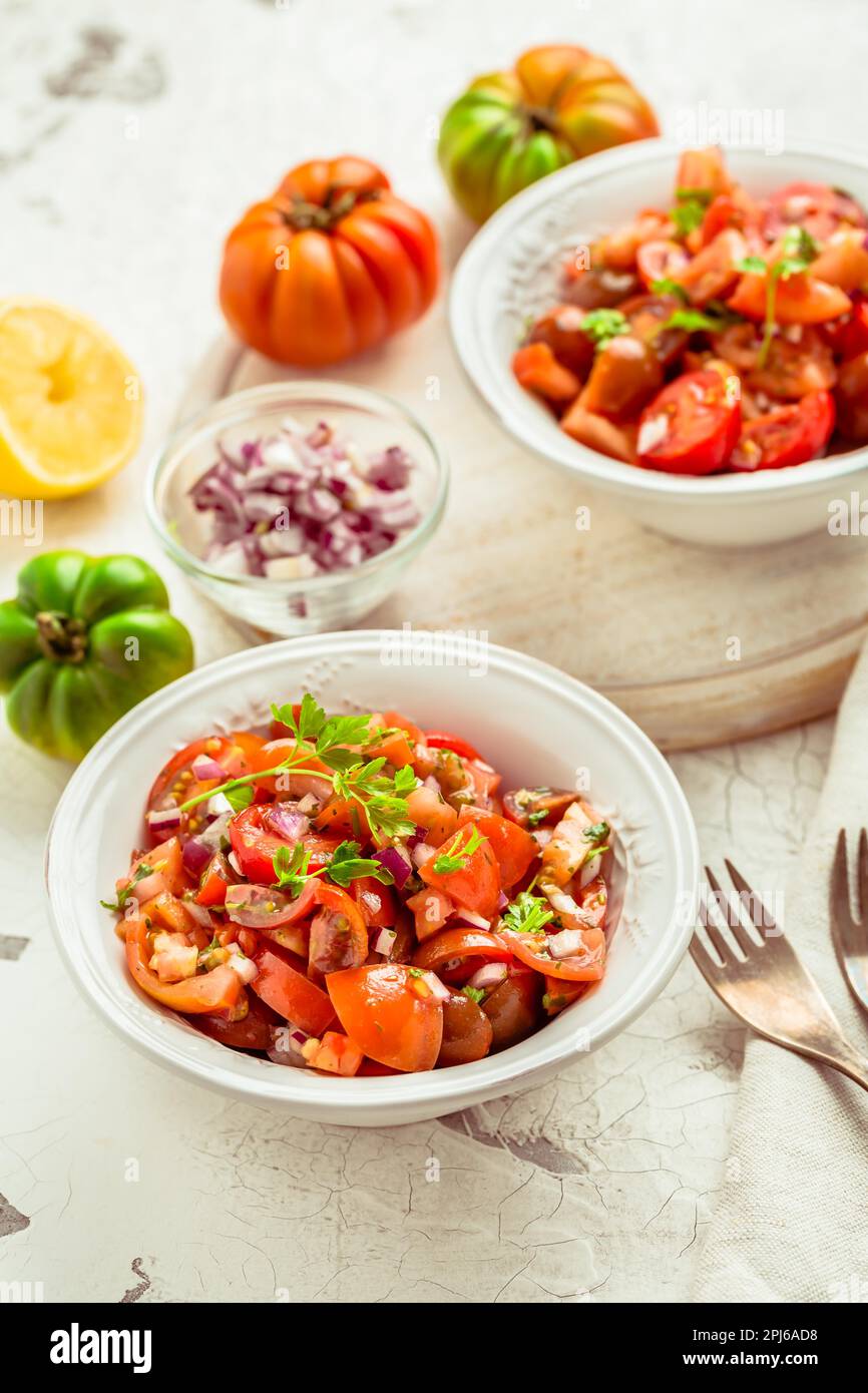 Mexican Pico de Gallo with ingredients - tomato salad, Mexica salsa with onion, parsley, coriander and lemon Stock Photo