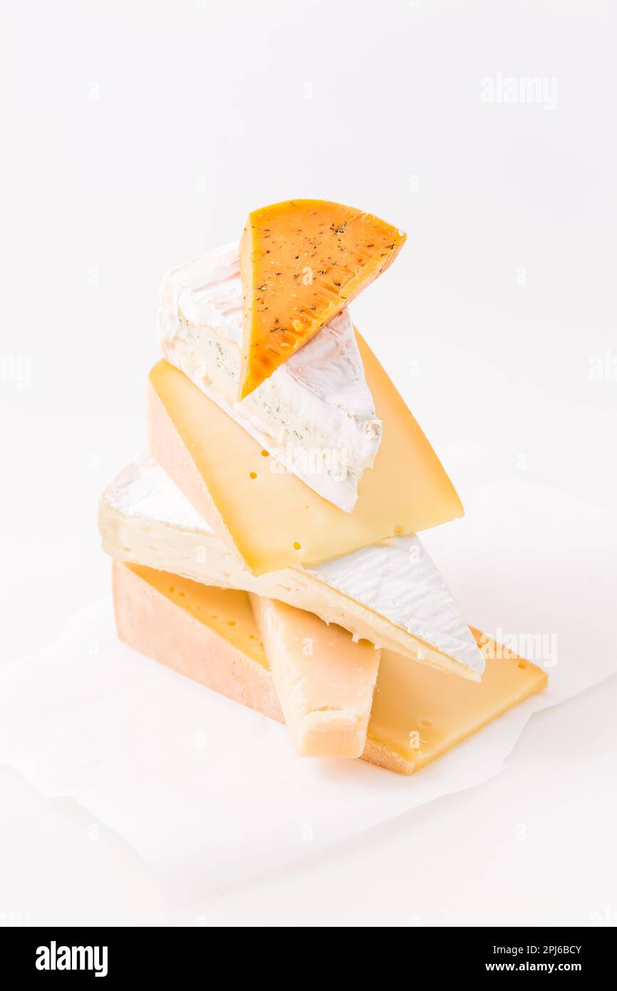 Assortment of different cheeses on white background. Hard cheese, parmesan, brie and chili cheese Stock Photo