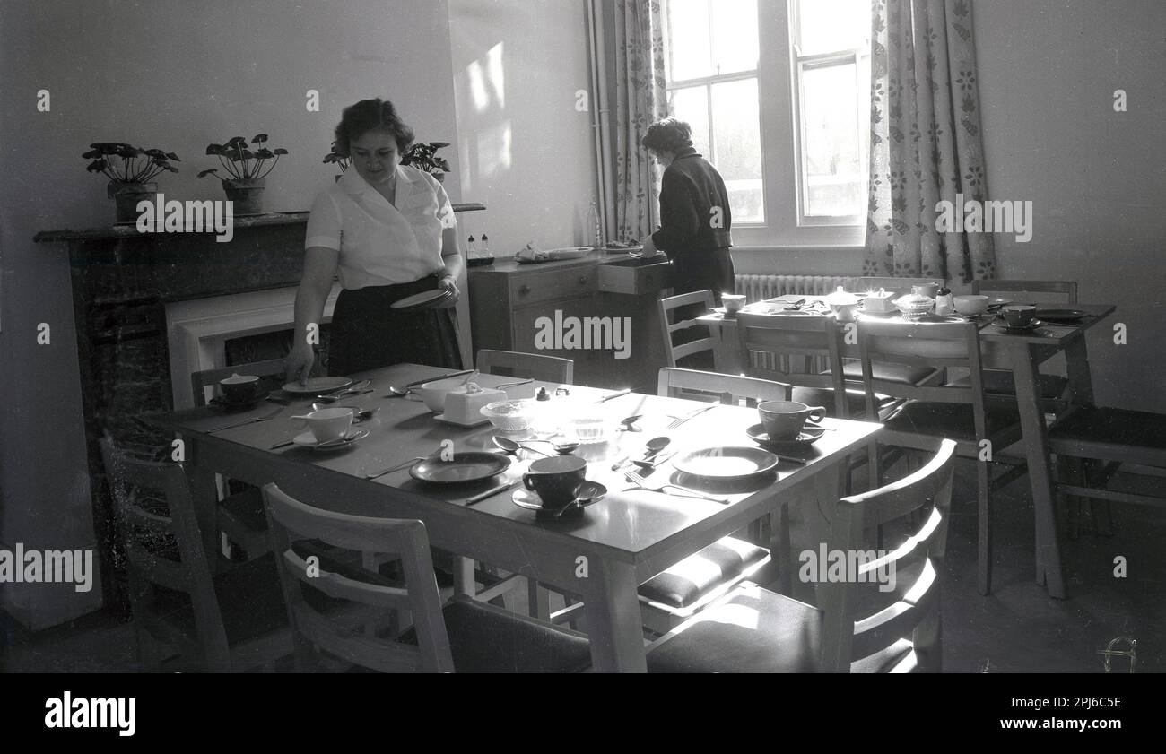 1950s, historical, female members of the kitchen staff laying tables in the dinning room at the hostel at Littlemore, a mental health facility at the Littlemore Hospital, Oxfordshire, England, UK. Stock Photo