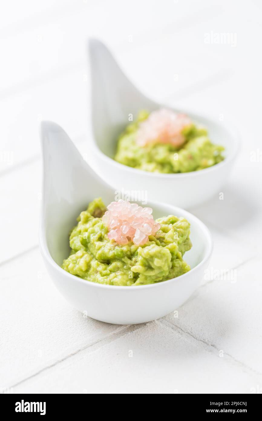 Fresh guacamole with caviar lime (Australian finger lime) fruits on white background Stock Photo
