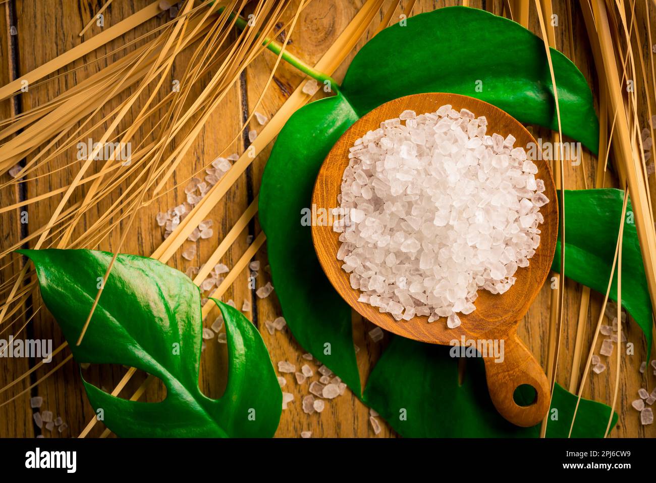 Spa salt with green leaf on wooden table. Healthy relaxation, therapy and treatment. Alternative lifestyle. Relax in bath Stock Photo
