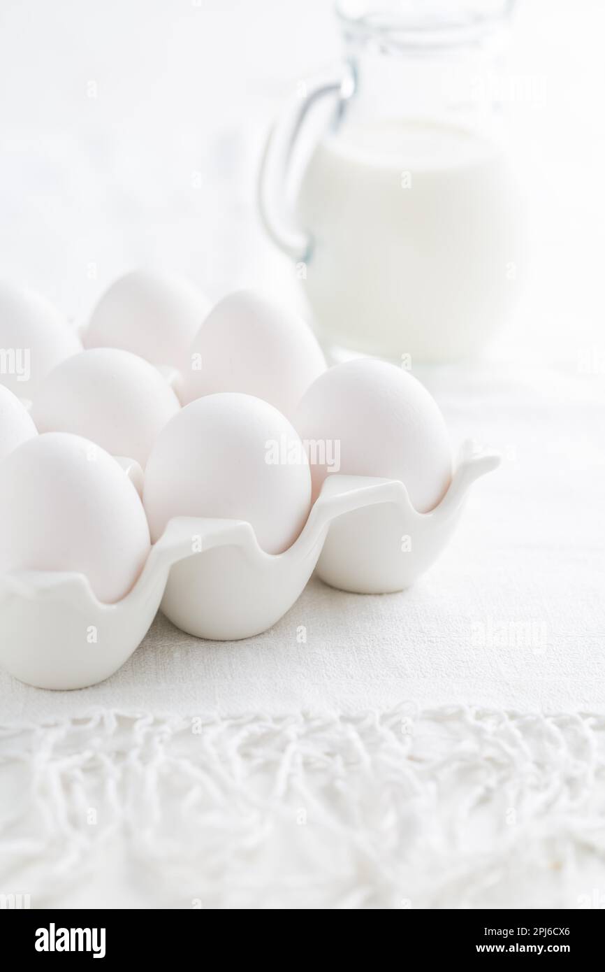 Organic milk and fresh eggs on white kitchen table Stock Photo