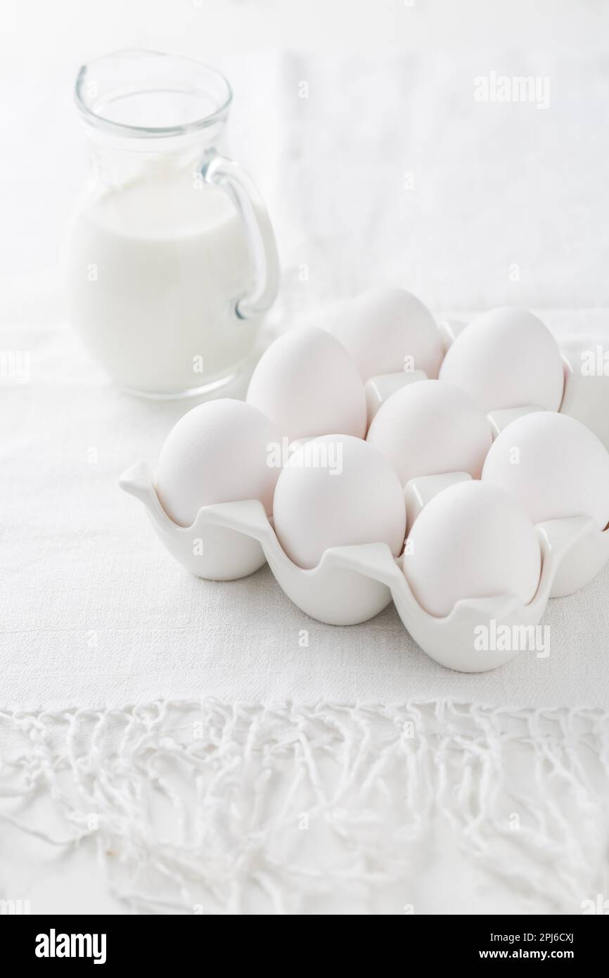 Organic milk and fresh eggs on white kitchen table Stock Photo