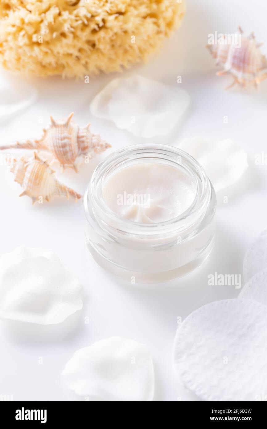 Open container with skin and body cream. Nourishing oil for clean and