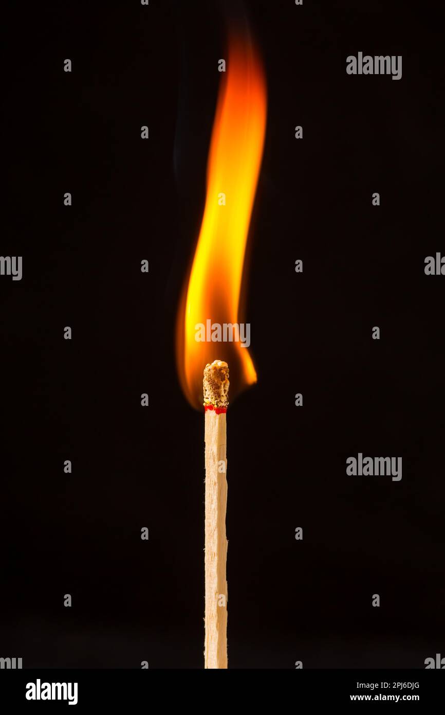 Burning matchstick on black background Stock Photo
