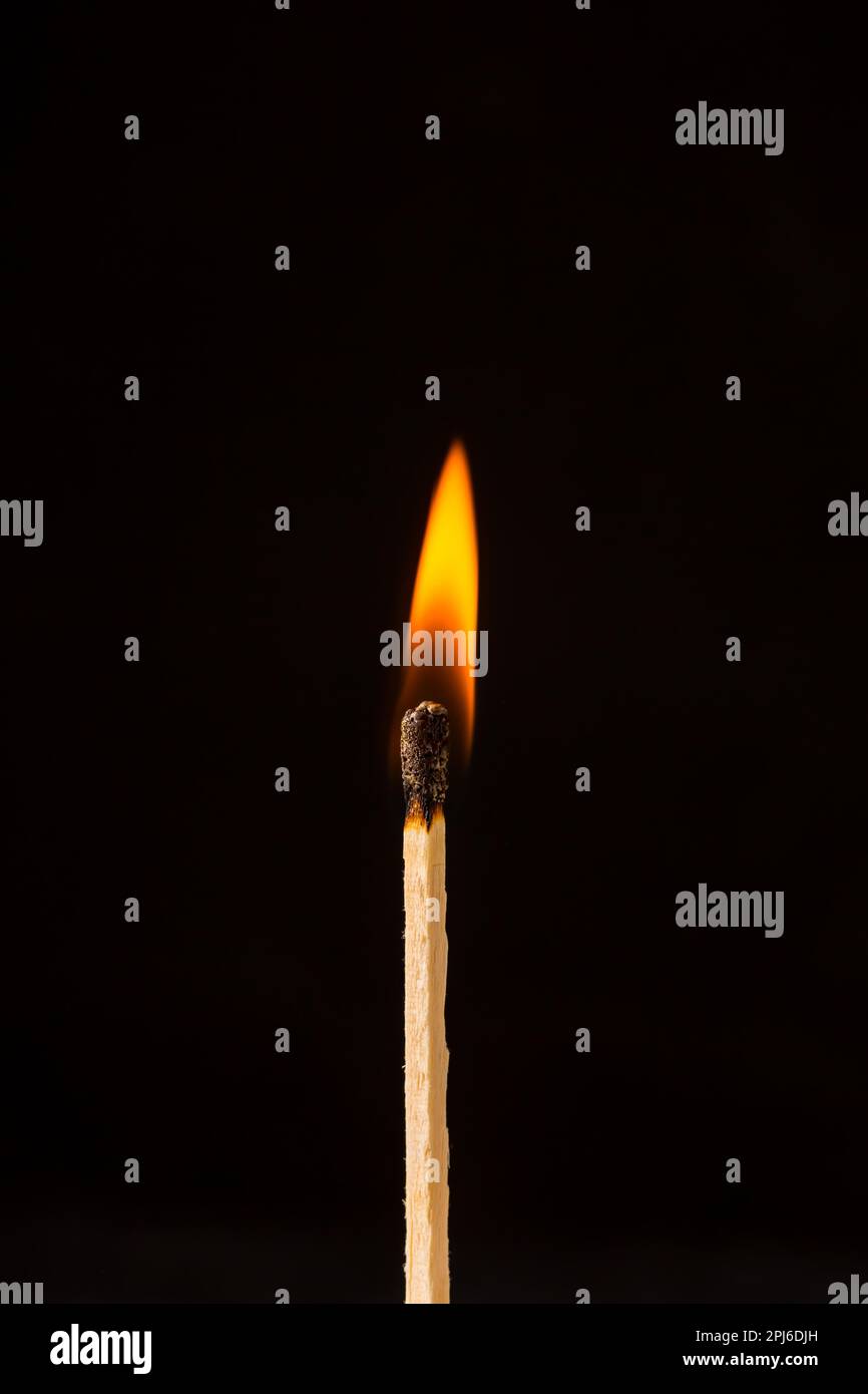 Burning matchstick on black background Stock Photo