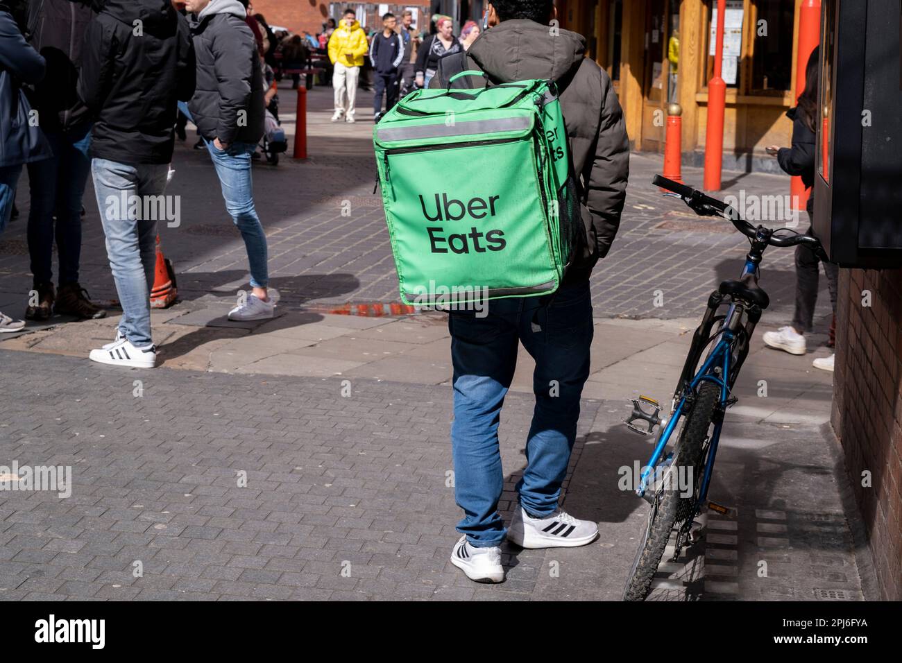 Uber Eats takeaway delivery cycle courier on 30th March 2023 in London, United Kingdom. Uber Eats is an online food ordering and delivery platform launched by Uber in 2014. It acts as an intermediary between independent takeaway food outlets and customers, with thousands of cycle couriers delivering food by bicycle and other forms of transport. Gig workers are independent contractors, online platform workers, contract firm workers, on-call workers and temporary workers. Gig workers enter into formal agreements with on-demand companies to provide services to the companys clients. Stock Photo
