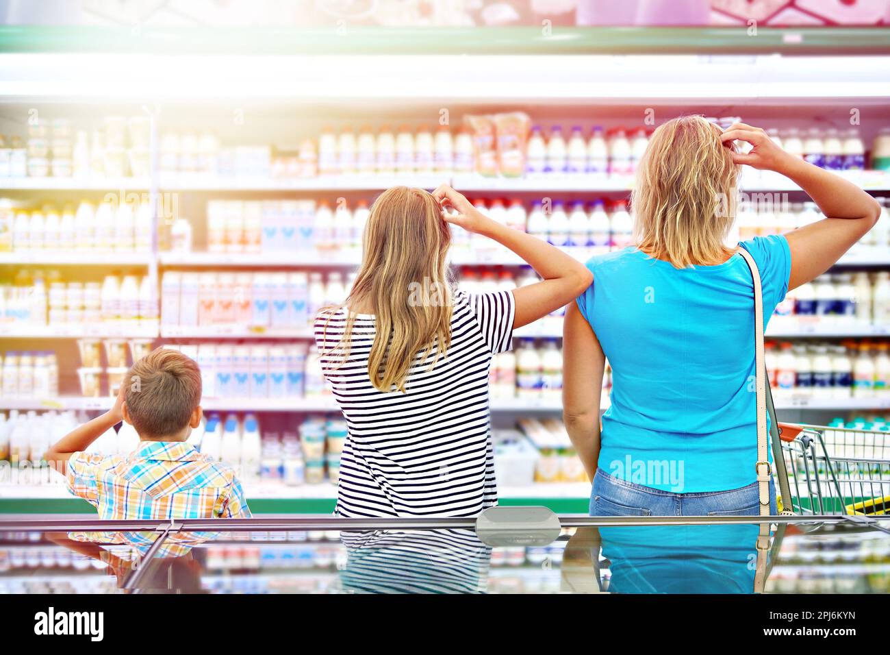 Mother and children are choosing dairy products in shop Stock Photo
