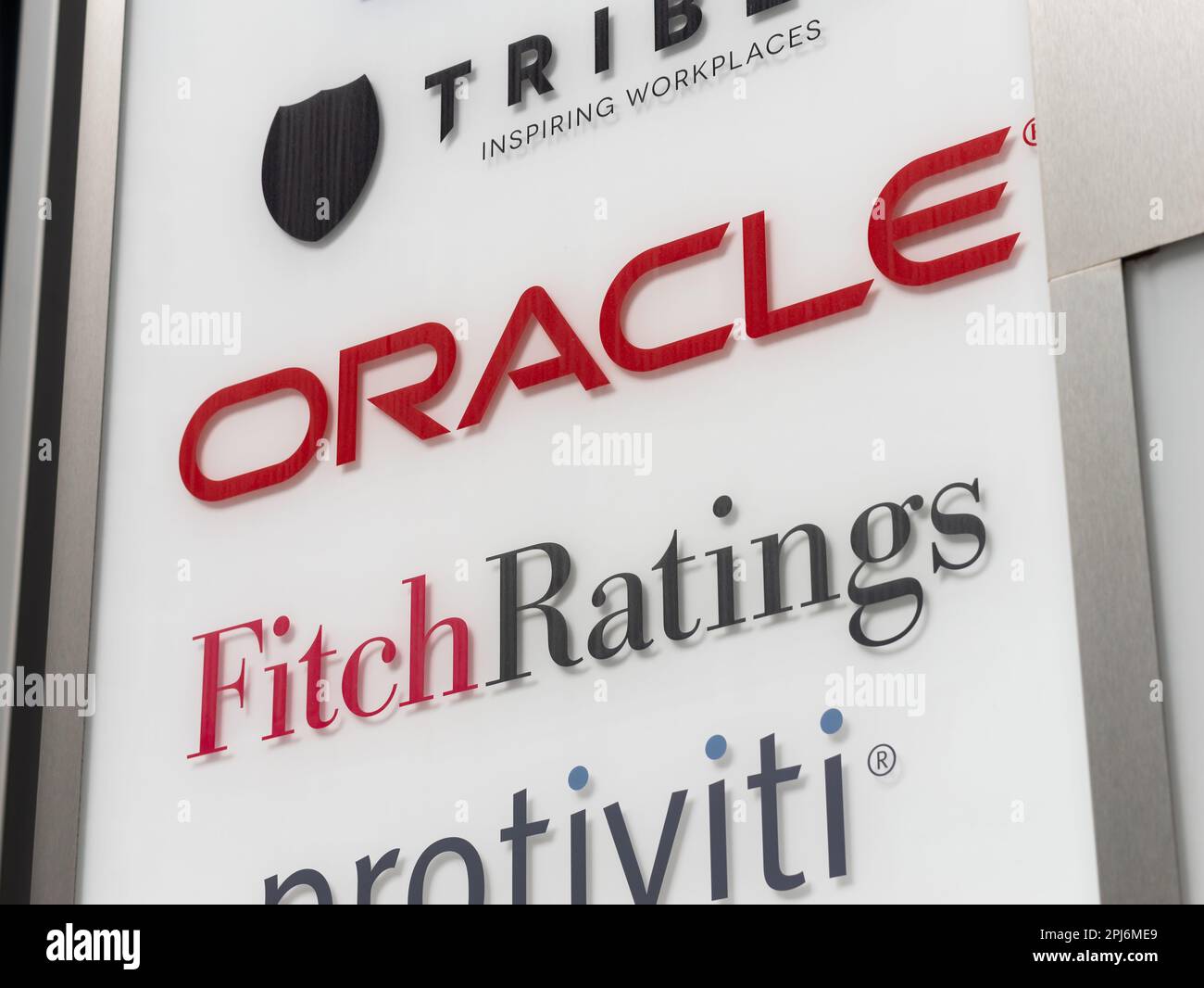 Oracle corporation and Fitch Ratings logo sign on the entrance of an office complex. American computer technology company and a credit rating agency. Stock Photo