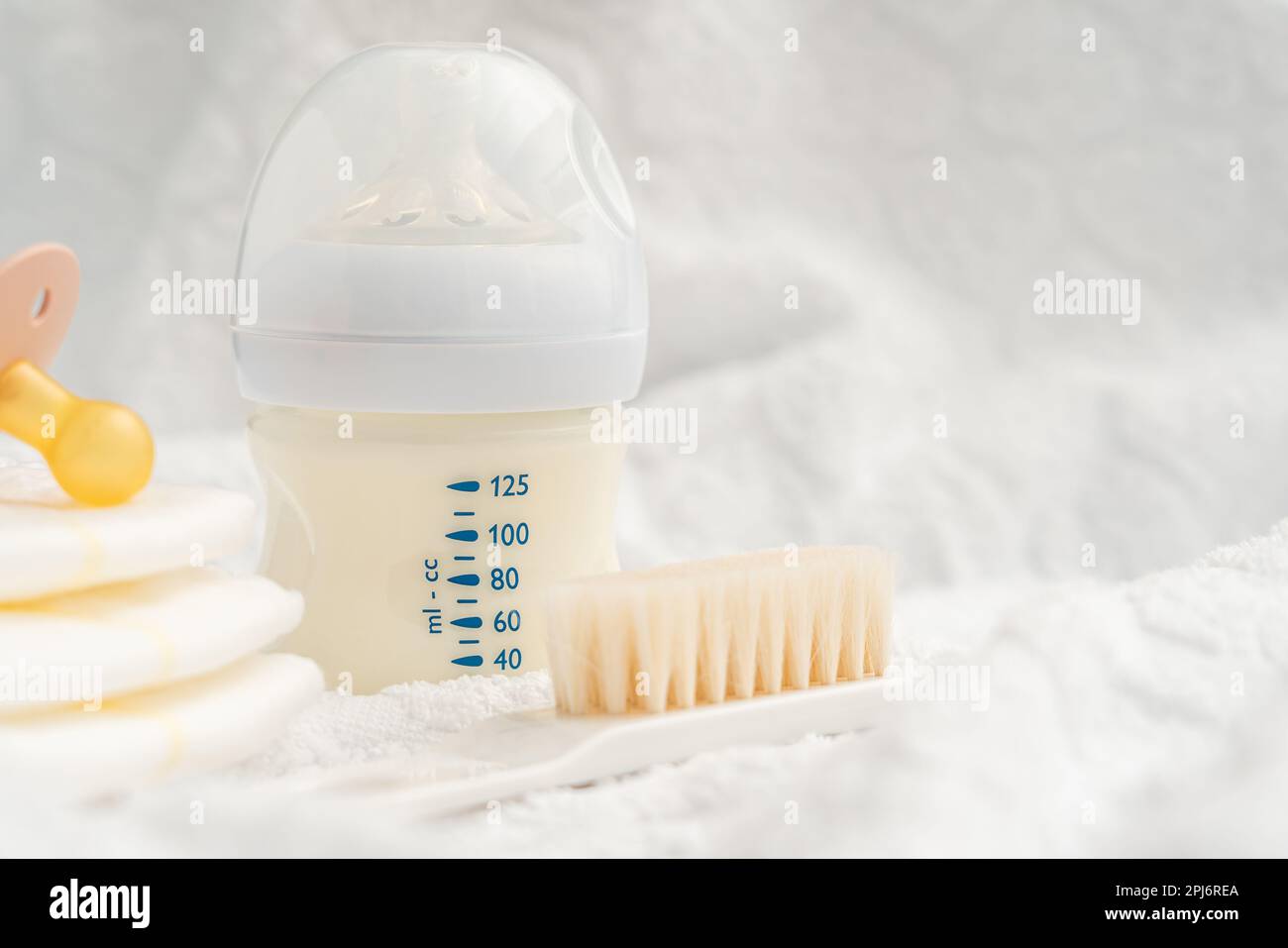 Newborn baby care. Bottle with milk mixture diapers and pacifier Stock