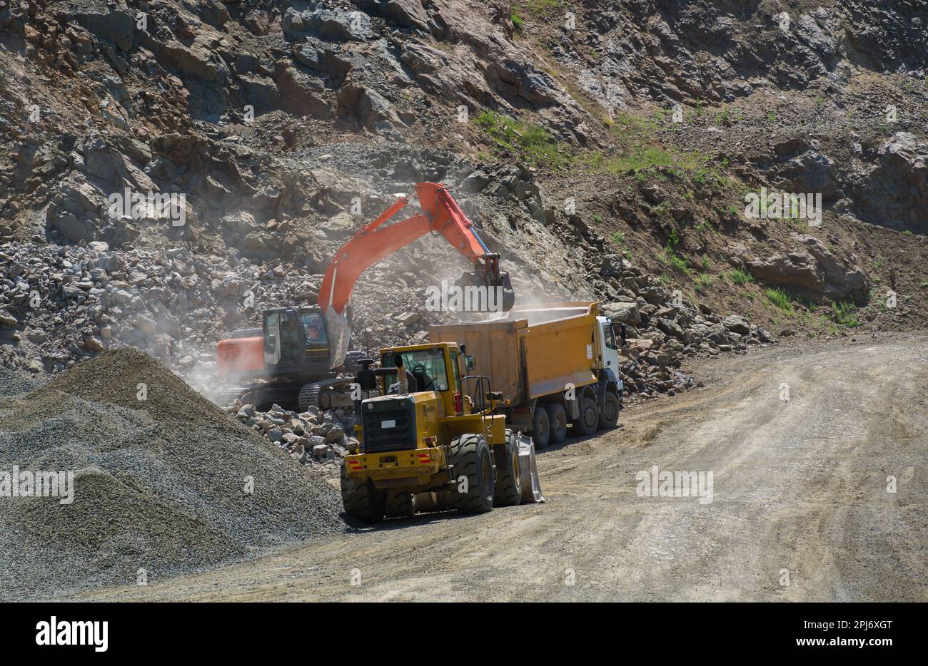 Construction work for the road. Excavator loads rock into truck. Road construction site Stock Photo
