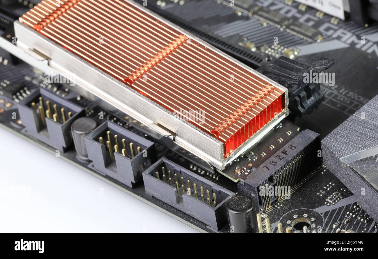 Solid state drives with copper heat sink for computer - ssd sata, NVME PCIe, SATA SSD m key, b key installed on modern computer motherboard. Stock Photo