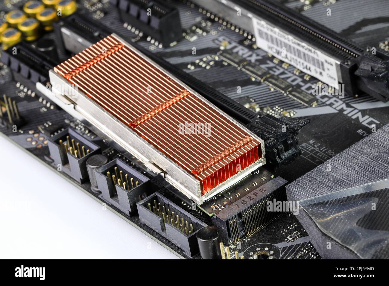 Solid state drives with copper heat sink for computer - ssd sata, NVME PCIe, SATA SSD m key, b key installed on modern computer motherboard. Stock Photo