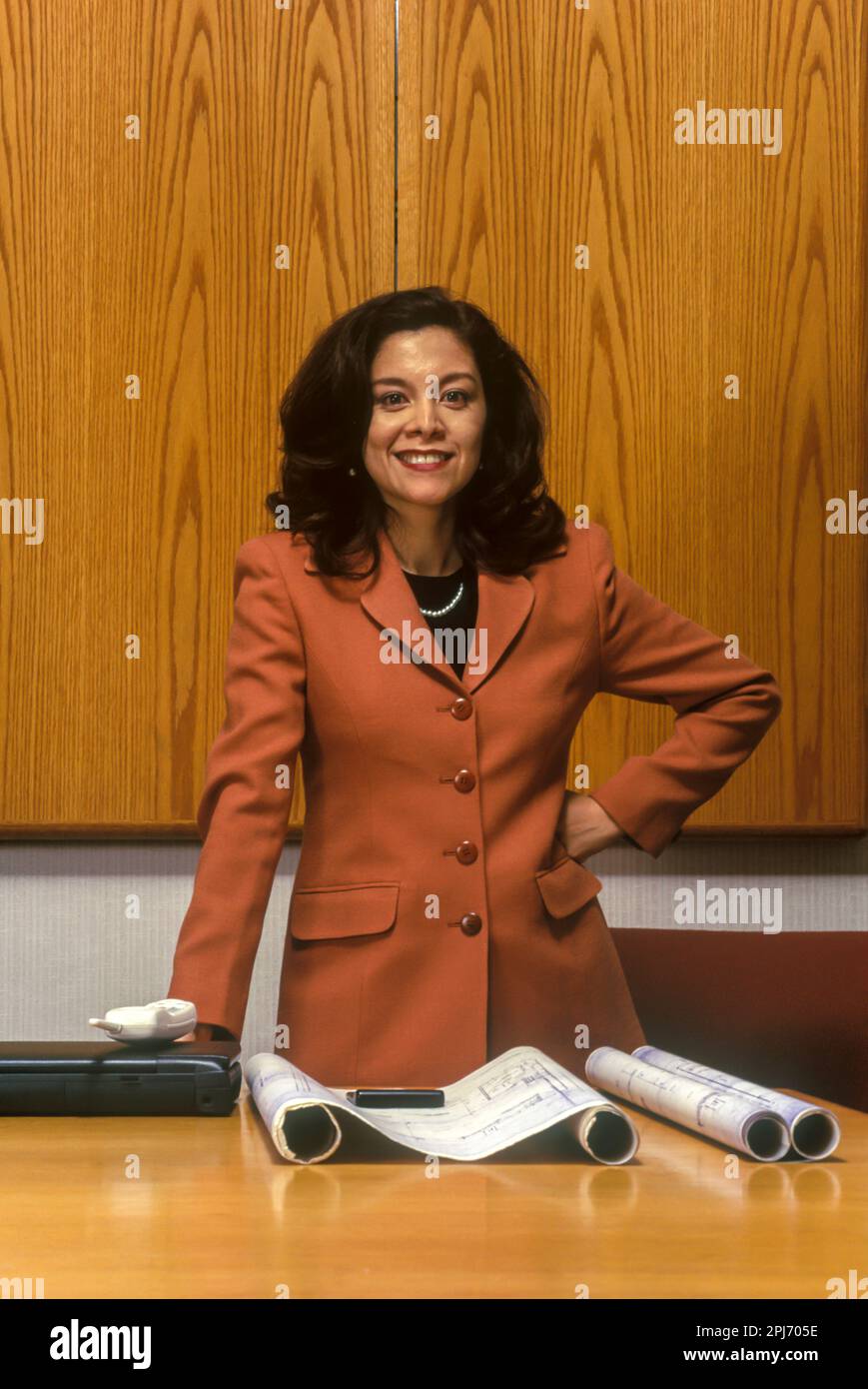 1996 HISTORICAL FEMALE HISPANIC OFFICE WORKER WITH CONSTRUCTION PLANS Stock Photo