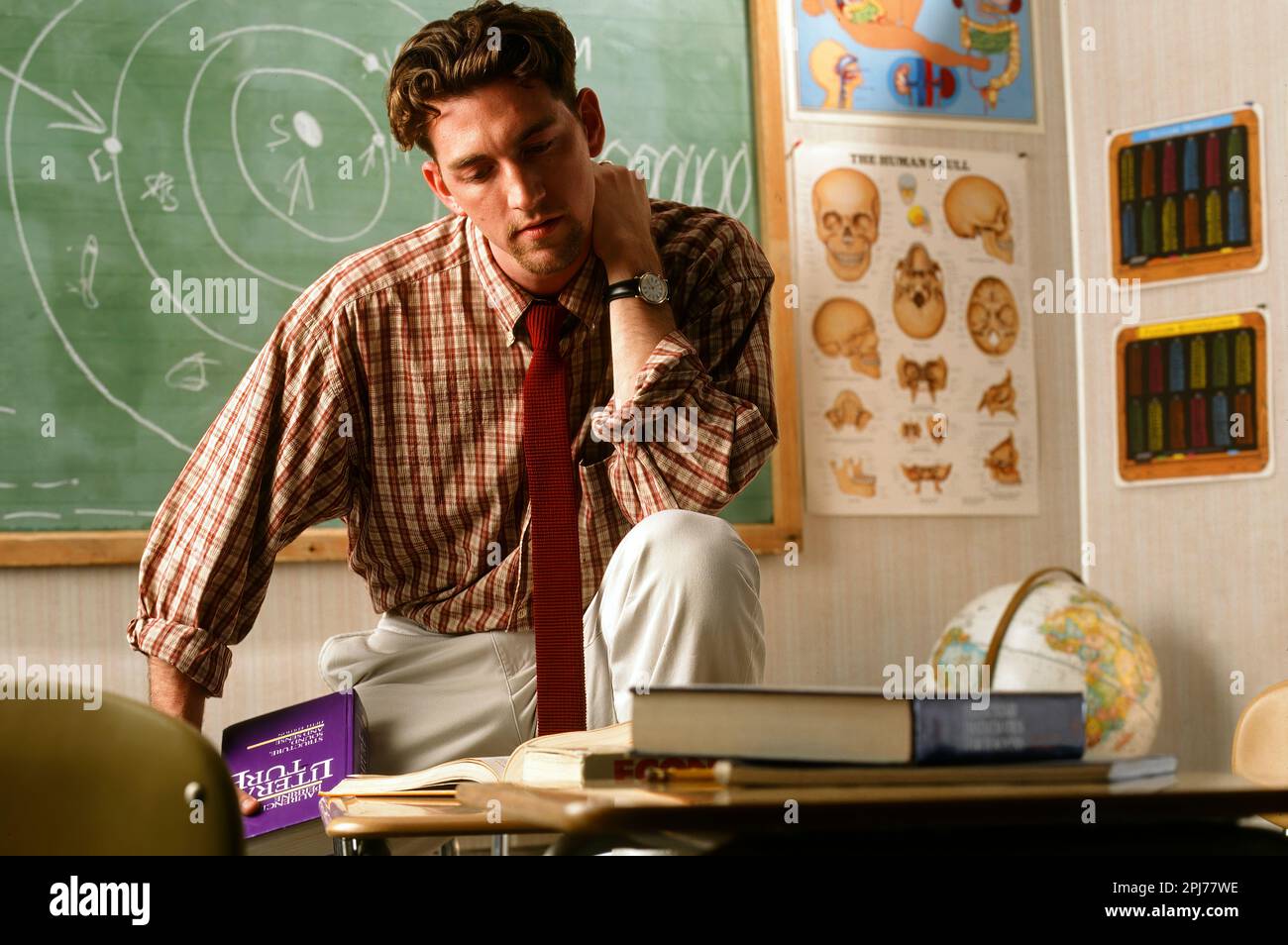 Caucasian male middle school teacher feeling stressed out in his classroom Stock Photo