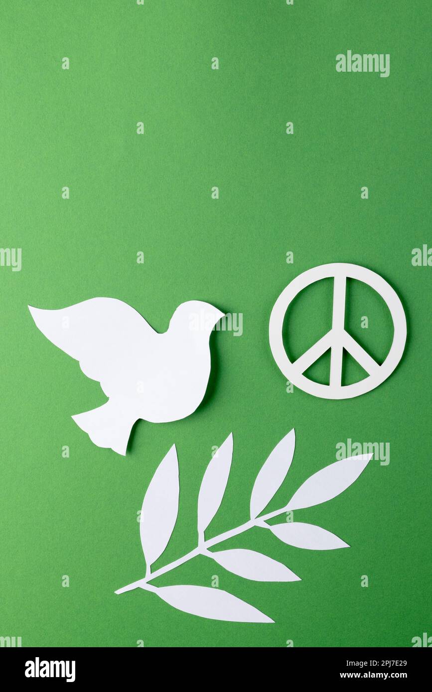 Close up of white dove and peace sign with leaves and copy space on ...