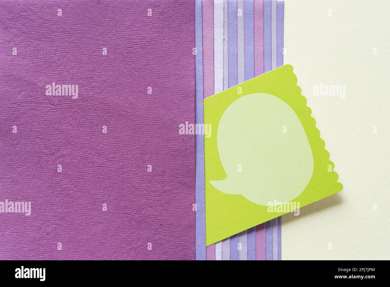 green card with large speech bubble and a variety of paper cards in mauve and pink or purple colour range and blank paper Stock Photo
