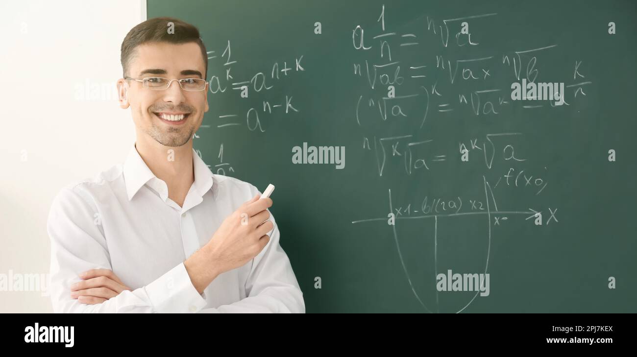 Happy teacher near chalkboard in classroom. Banner design Stock Photo ...