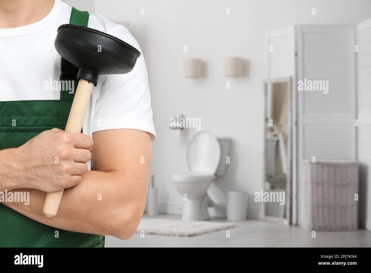 https://c8.alamy.com/comp/2PJ7KN4/plumber-holding-plunger-in-bathroom-closeup-space-for-text-2PJ7KN4.jpg