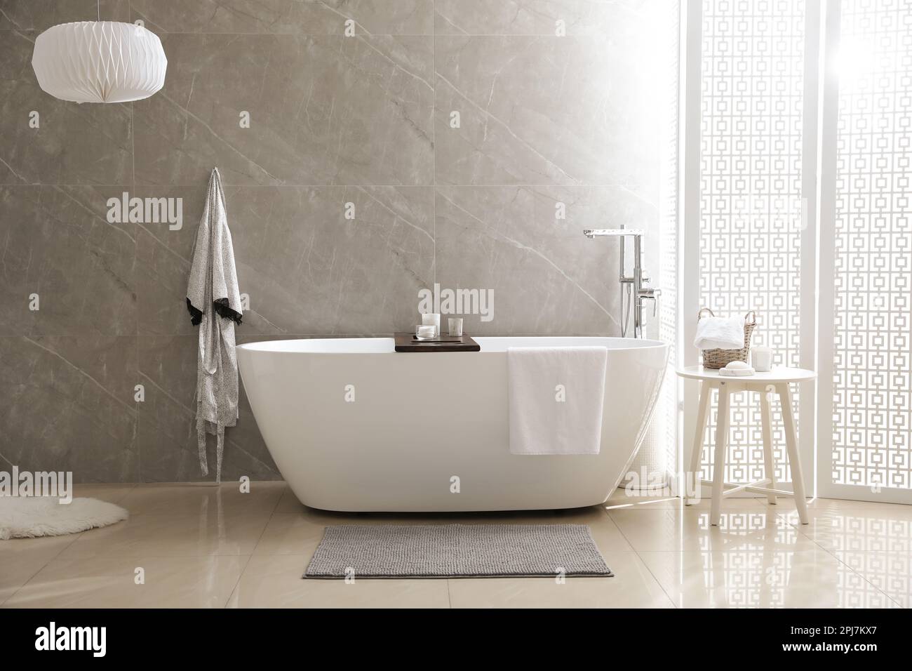 Modern white tub and table with toiletries in bathroom. Interior design ...