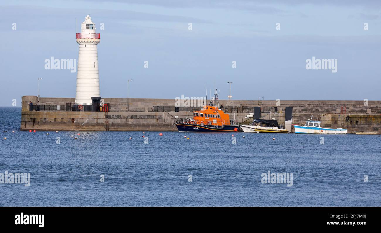 Boats in harbour quay and white daymark lighthouse on east coast Northern Ireland at Donaghadee County Down Northern Ireland on sunny spring day. Stock Photo