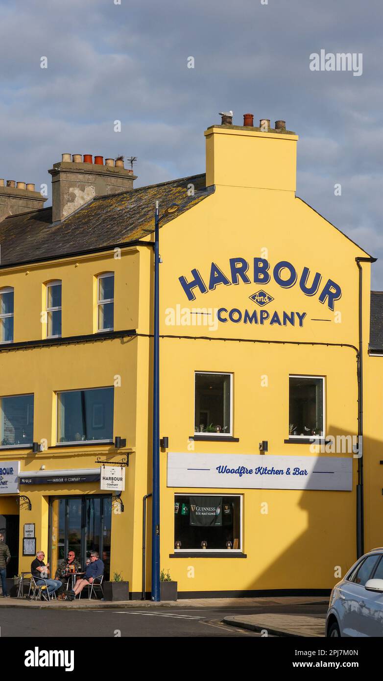 Sunny day coastal town Northern Ireland, group adult males outside