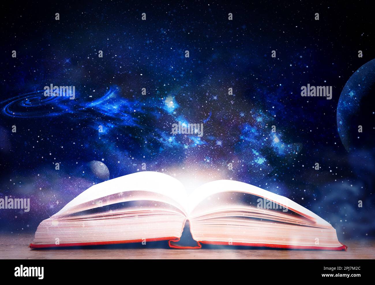 Wooden table with open book and beautiful universe on background Stock