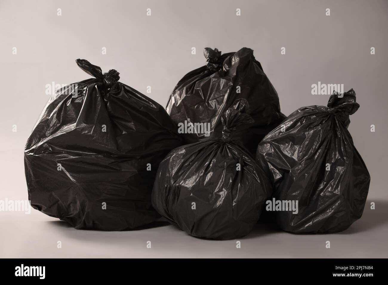 https://c8.alamy.com/comp/2PJ7NB4/trash-bags-full-of-garbage-on-grey-background-2PJ7NB4.jpg