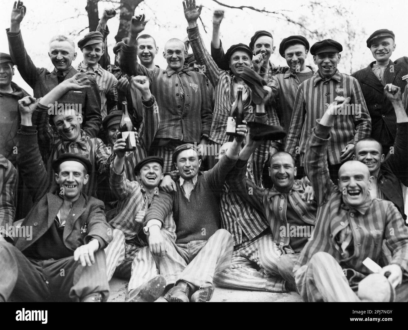 Jubilant prisoners waving at the American soldiers as the gates of Dachau concentration camp are opened and the prisoners freed.  American Soldiers of the U.S. 7th Army, including members of the 42nd Infantry and 45th Infantry and 20th Armored Divisions participated in the camp’s liberation. Stock Photo