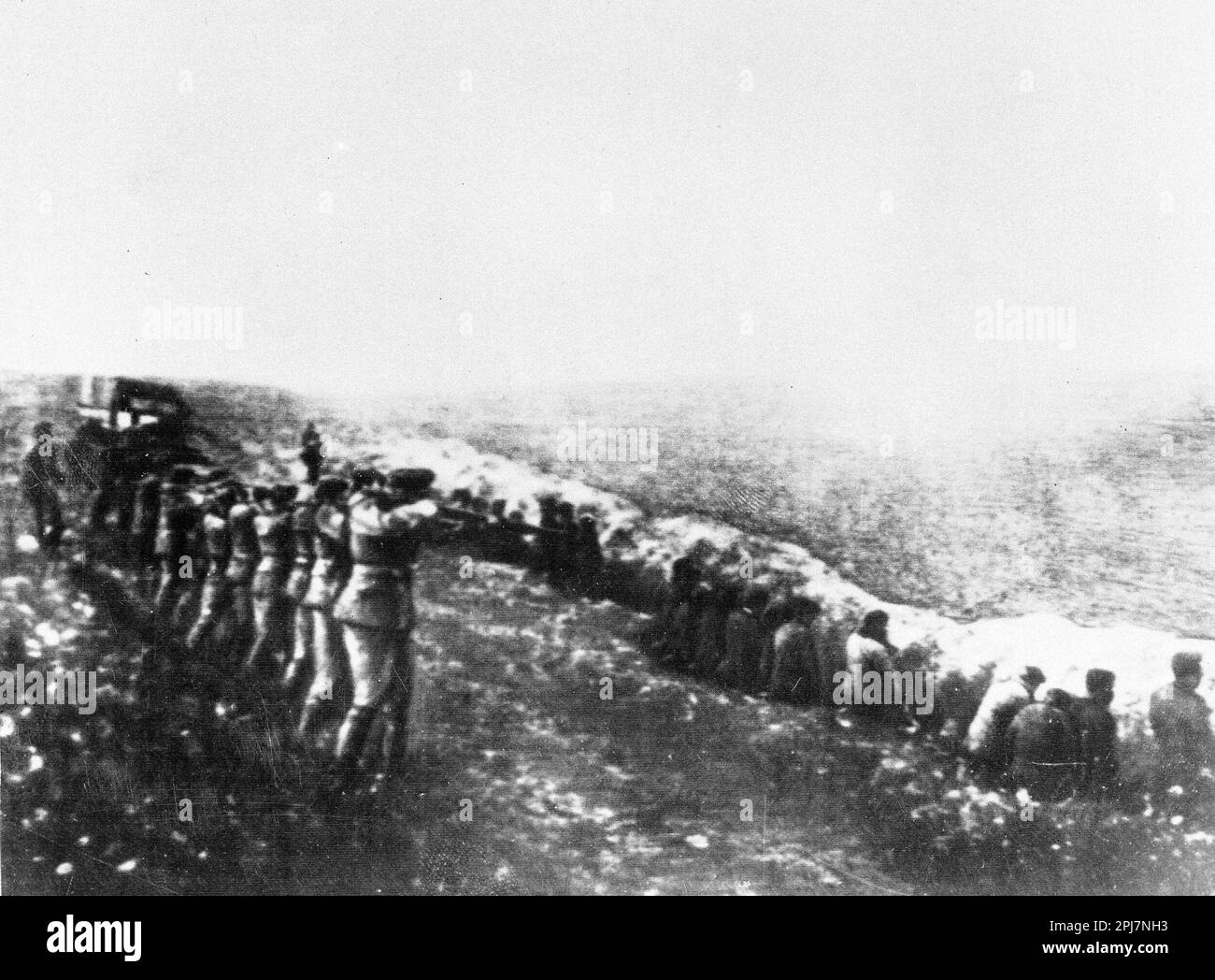 This photo was taken from a the body of a dead Germany officer killed in Russia, showing a German firing squad shooting Soviet civilians in the back as they sit beside their own mass grave,  in Babi Yar, Kiev, 1942. Stock Photo
