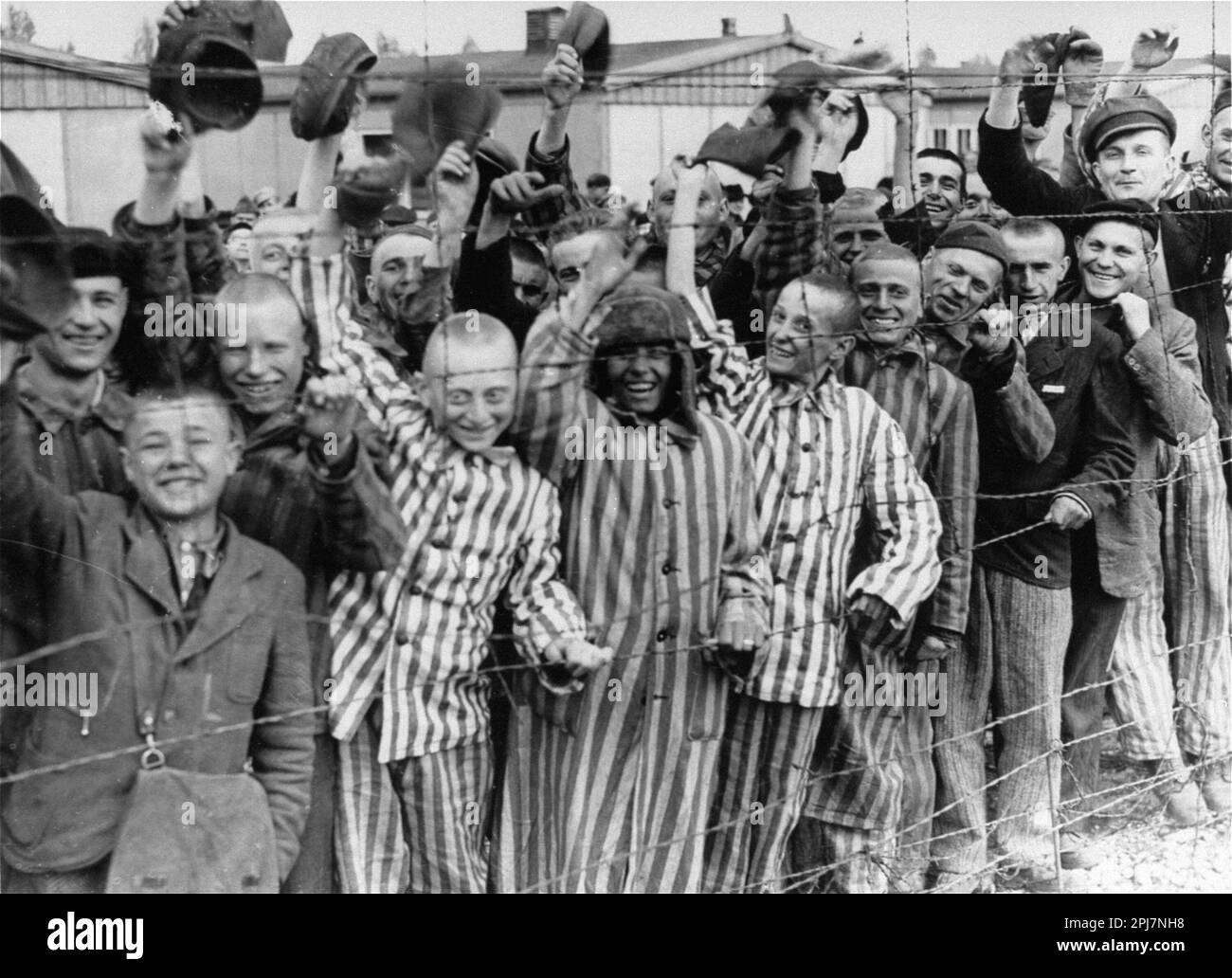 Happy child prisoners waving at the American soldiers as the gates of Dachau concentration camp are opened and the prisoners freed. American Soldiers of the U.S. 7th Army, including members of the 42nd Infantry and 45th Infantry and 20th Armored Divisions participated in the camp’s liberation. Stock Photo